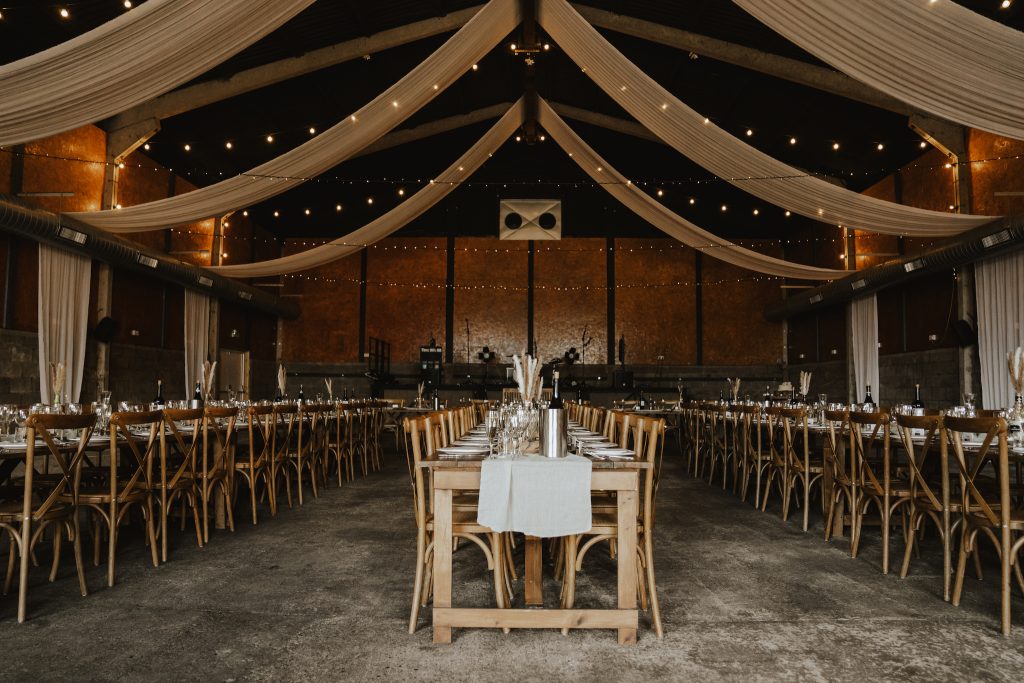 The Barns at Lodge Farm, grain room with banquet tables. Essex wedding photographer.