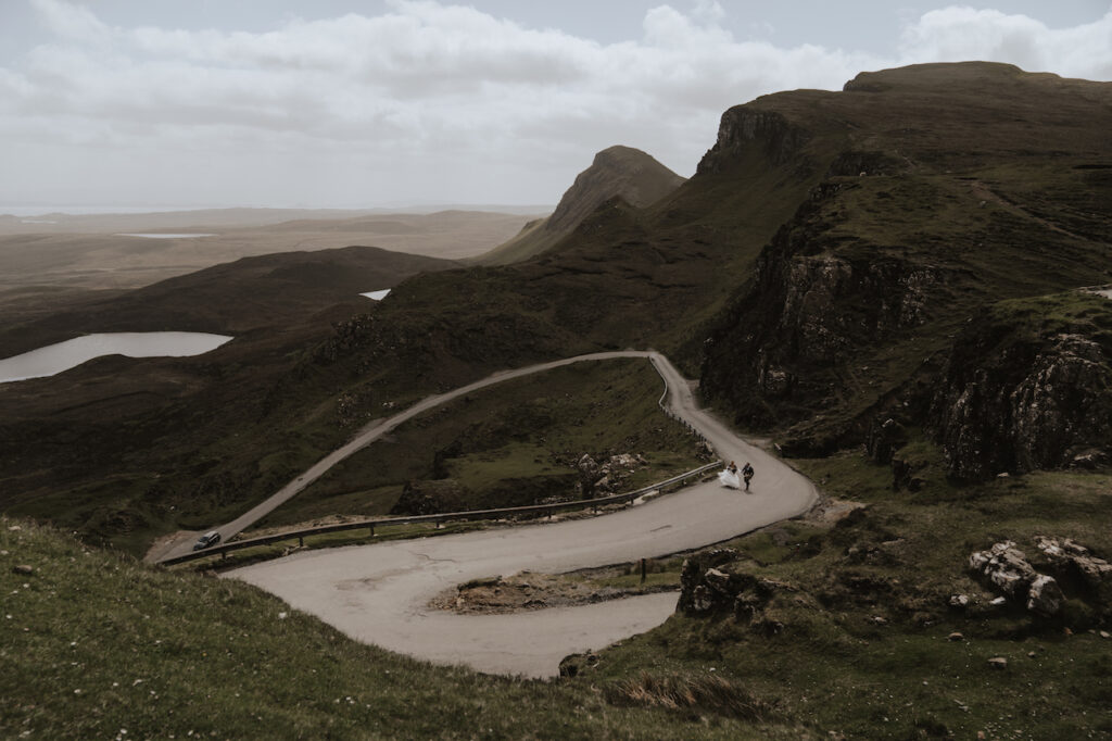An eloping couple running up the famous Quiraing road on the Isle of Skye