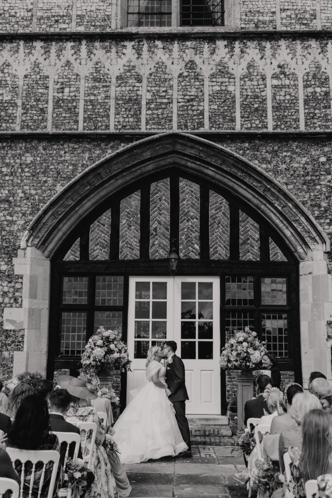 The first kiss during the ceremony in the gardens of Butley Priory