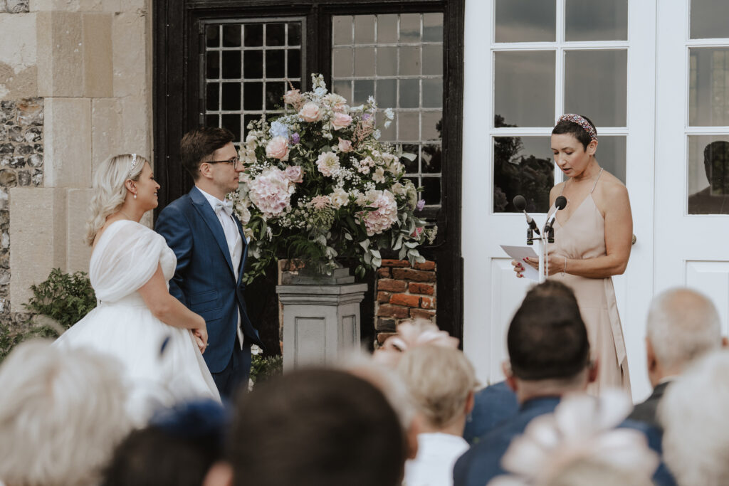 Suffolk wedding photographer capturing a reading during the ceremony at Butley Priory