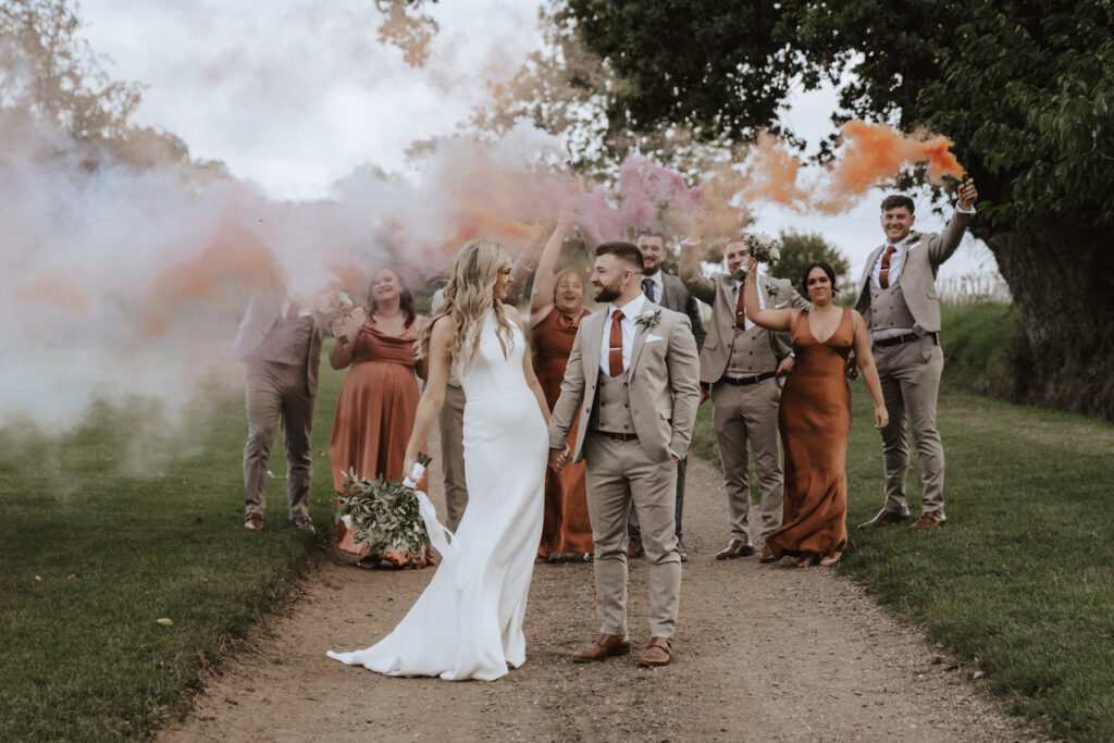 Smoke flares with the bride, groom and bridal party at a Suffolk wedding
