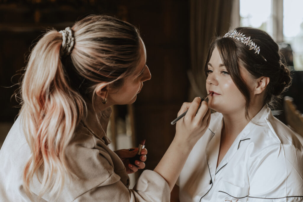 The bride having makeup touch ups at Hengrave Hall