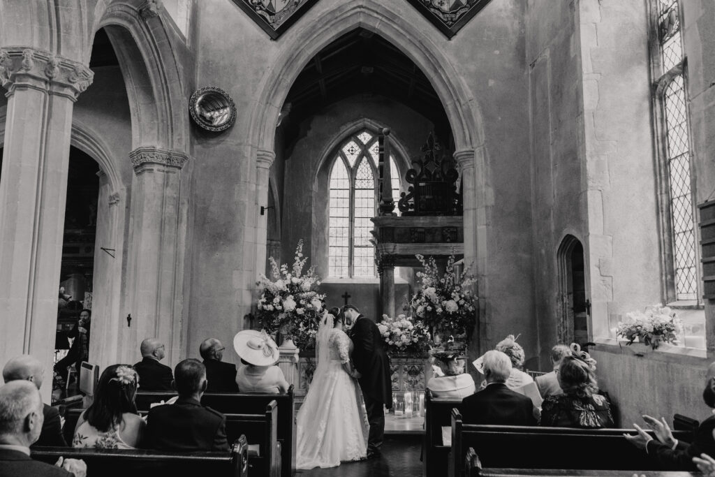 First kiss during the ceremony at Hengrave Chapel in Suffolk