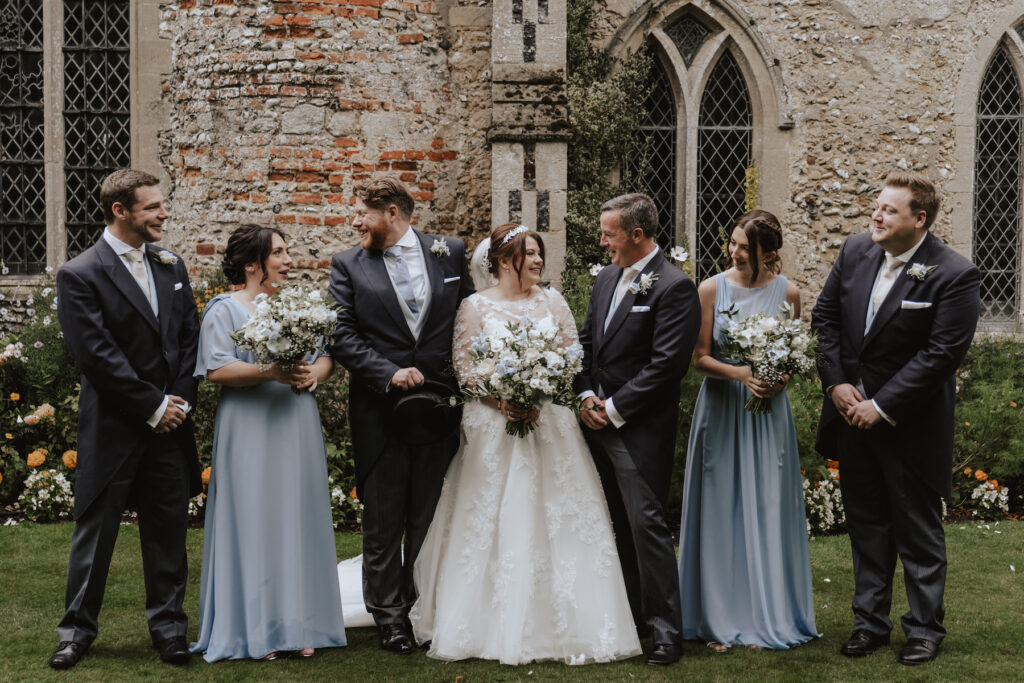 The couple with their bridesmaids and groomsmen during formal photos at Hengrave Chapel