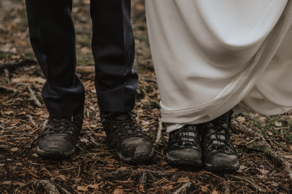 Eloping couple wearing hiking boots with their wedding outfit in The Lake District