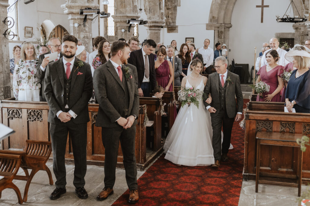 Wedding photographer in the midlands capturing the bride walking down the church aisle