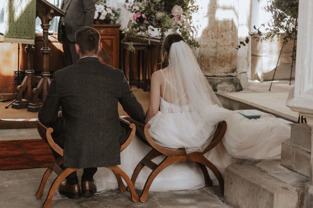 The couple seated during their church ceremony captured by a midlands wedding photographer