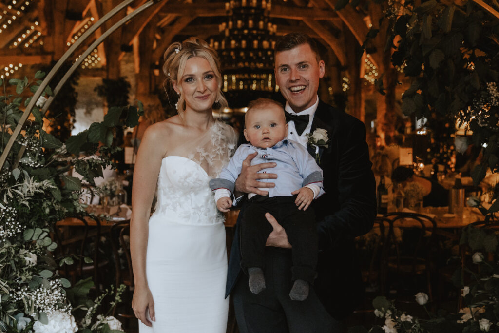 The couple and their son during their wedding breakfast at Tithe Barn in Yorkshire