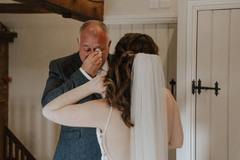 The bride's dad seeing her in her wedding dress for the first time at the bridal suite