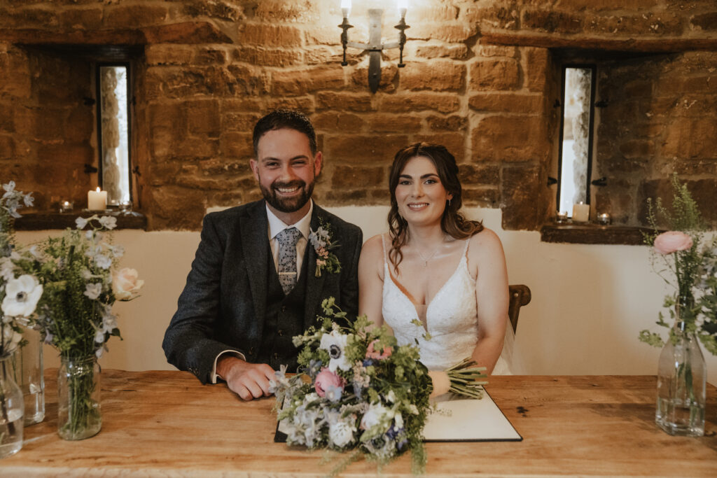The couple signing the register at Crockwell Farm during their ceremony