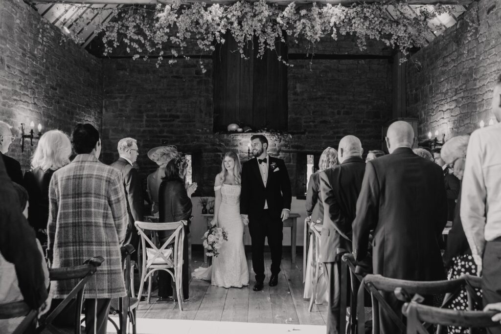 Walking back down the aisle after the wedding ceremony in the ceremony barn at Crockwell Farm