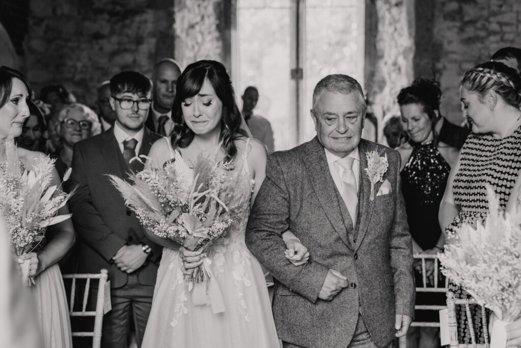 Emotional moments as the bride walks down the aisle at Norfolk's Pentney Abbey