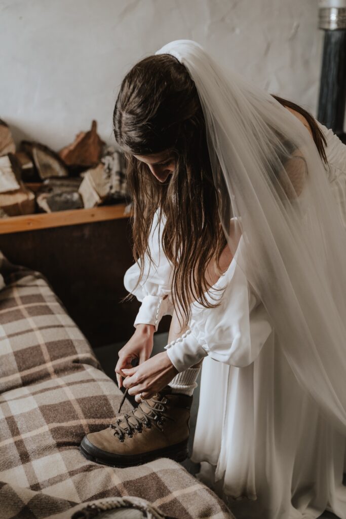 The bride putting on walking boots before adventuring on her Scotland elopement