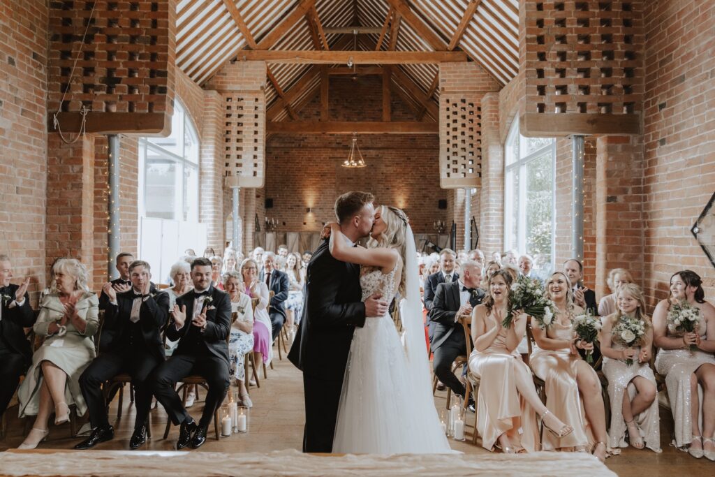 The first kiss during the ceremony at Swallows Nest Barn in Warwick