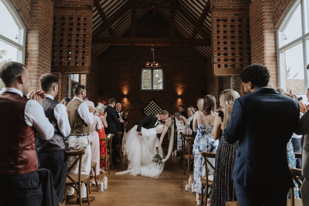 A couple walking down the aisle after becoming legally married at Swallows Nest Barn
