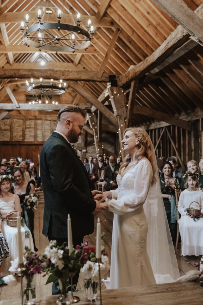 A couple exchanging rings during their ceremony at Bassmead Manor Barns in Cambridgeshire