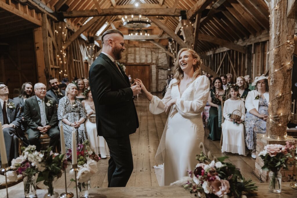 The couple laughing during their ceremony at Bassmead Manor Barns in Cambridgeshire