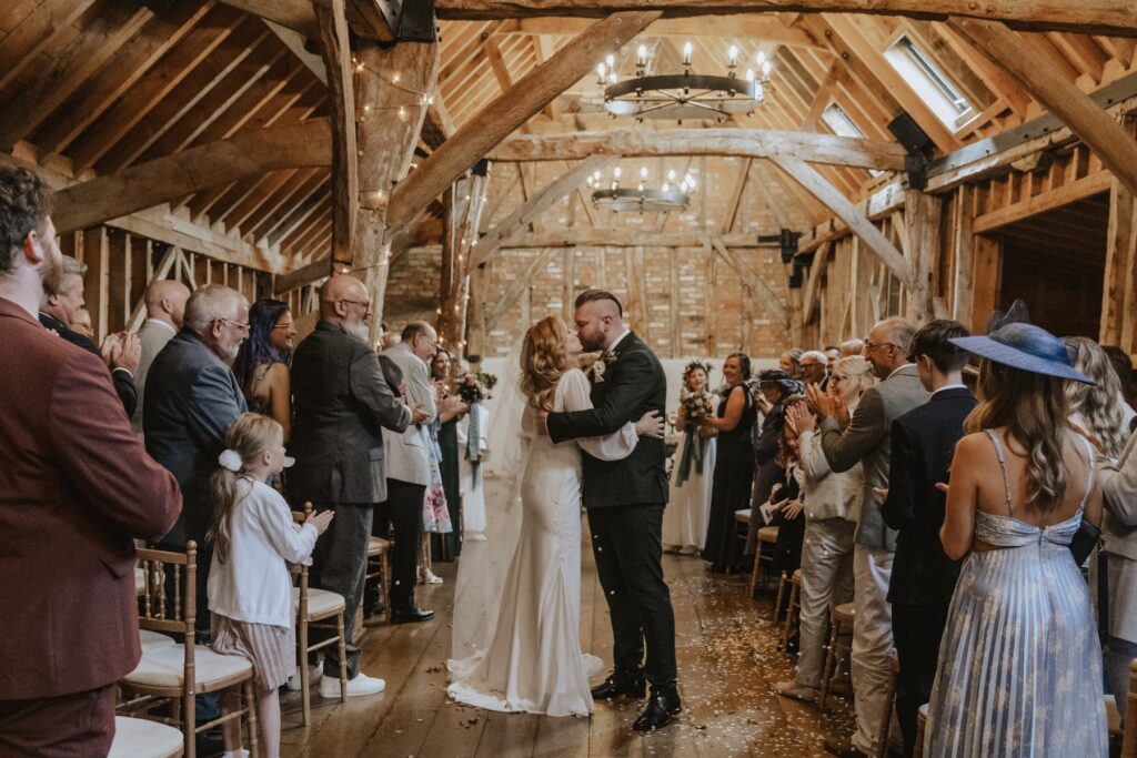 Cambridgeshire wedding photographer capturing a couple walking back down the aisle together at at Bassmead Manor Barns in St Neots