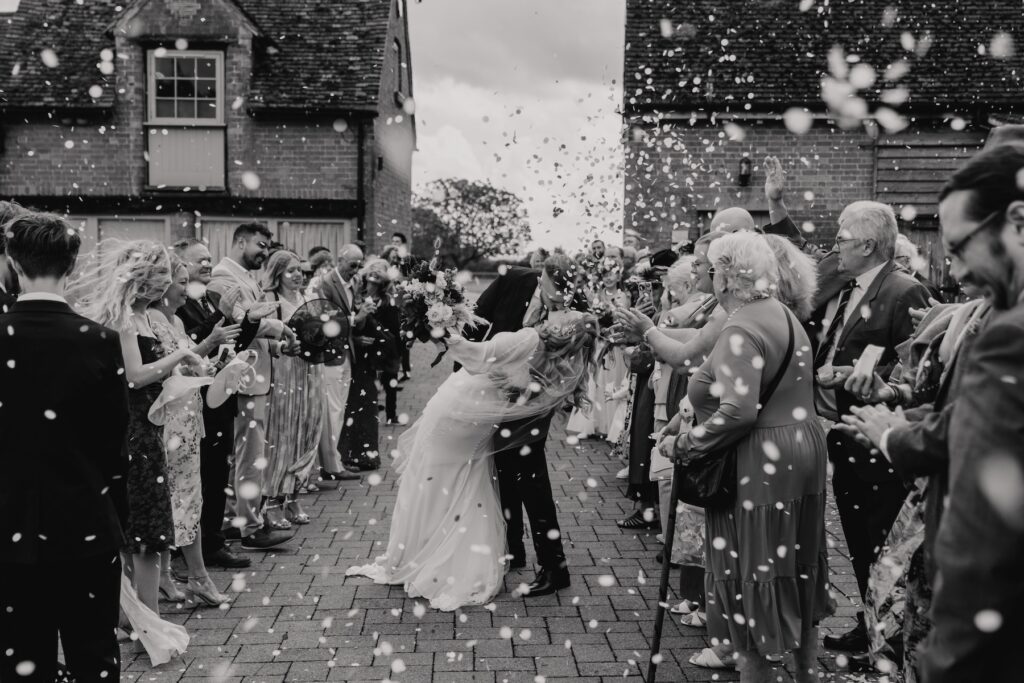 The couple walking down the confetti line at Bassmead Manor Barns in St Neots, Cambridgeshire