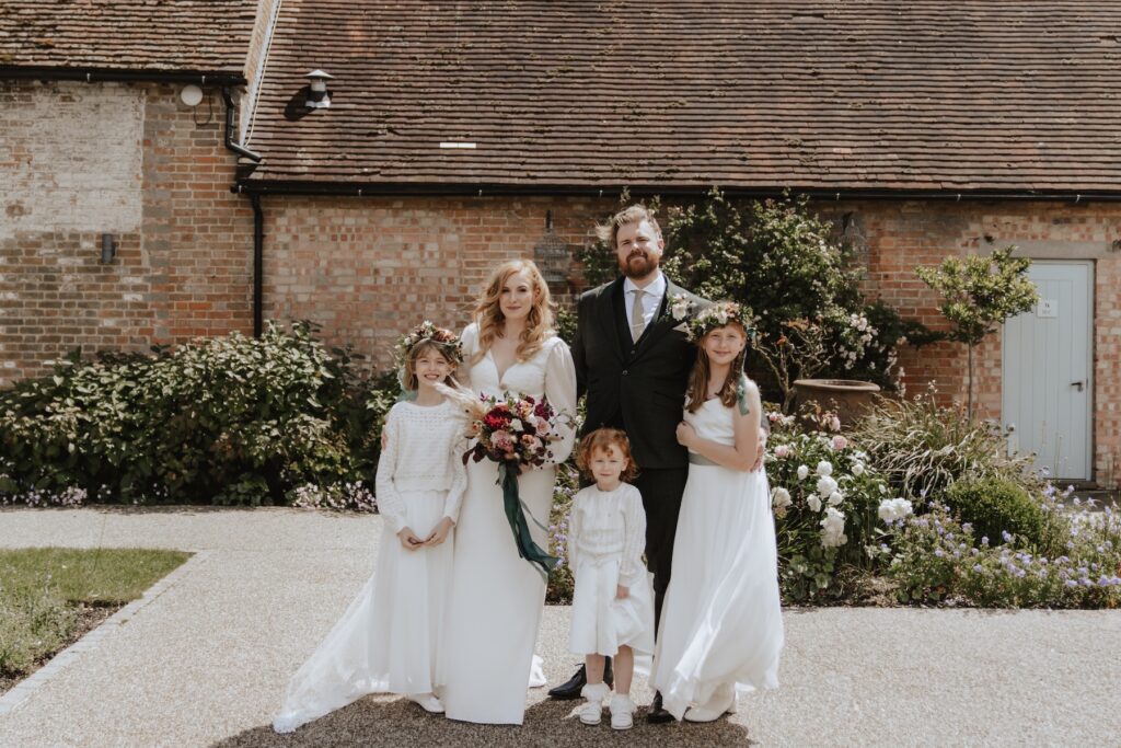Wedding portraits with the bride, groom and their daughters at Bassmead Manor Barns in Cambridgeshire