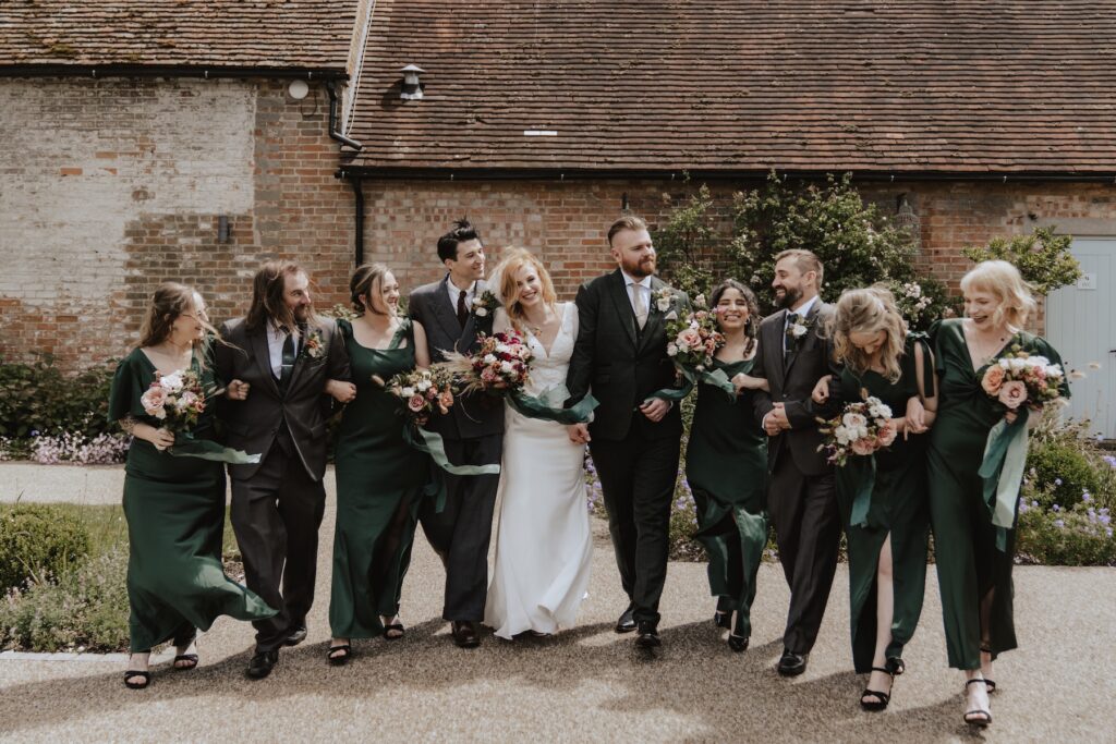 Relaxed wedding portraits with bridesmaids and groomsmen at Bassmead Manor Barns in Cambridgeshire