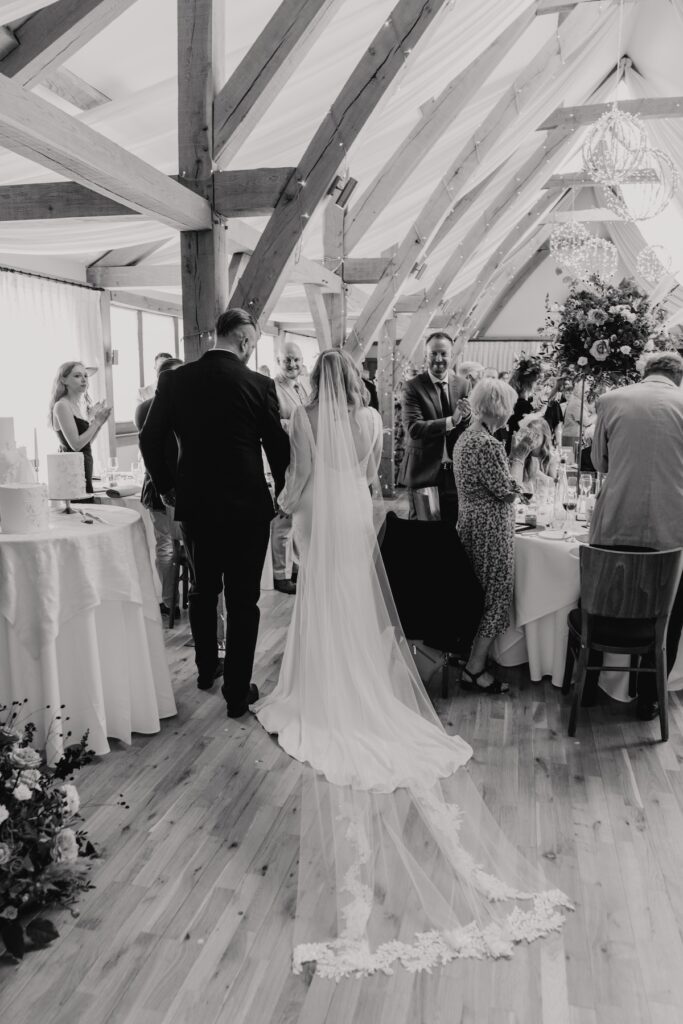 The couple walking into their wedding breakfast at Bassmead Manor Barns in Cambridgeshire