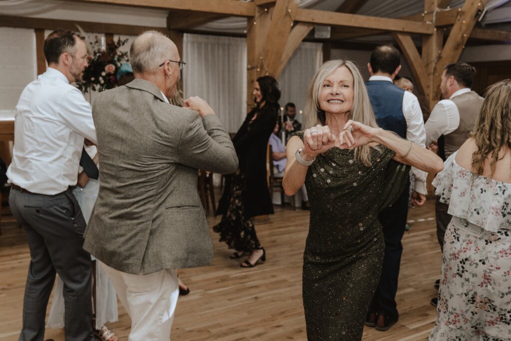 Guests dancing on the dance floor in the evening of a wedding at Bassmead Manor Barns in Cambridge
