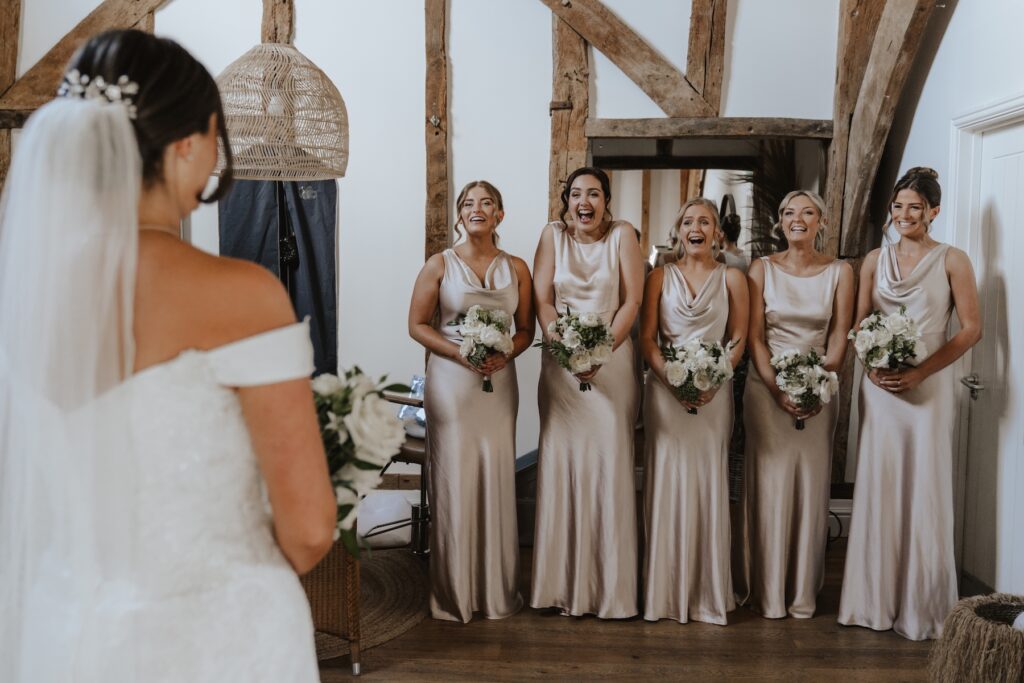 The bridesmaids reacting to the bride being ready in the morning of the wedding at Easton Grange in Suffolk