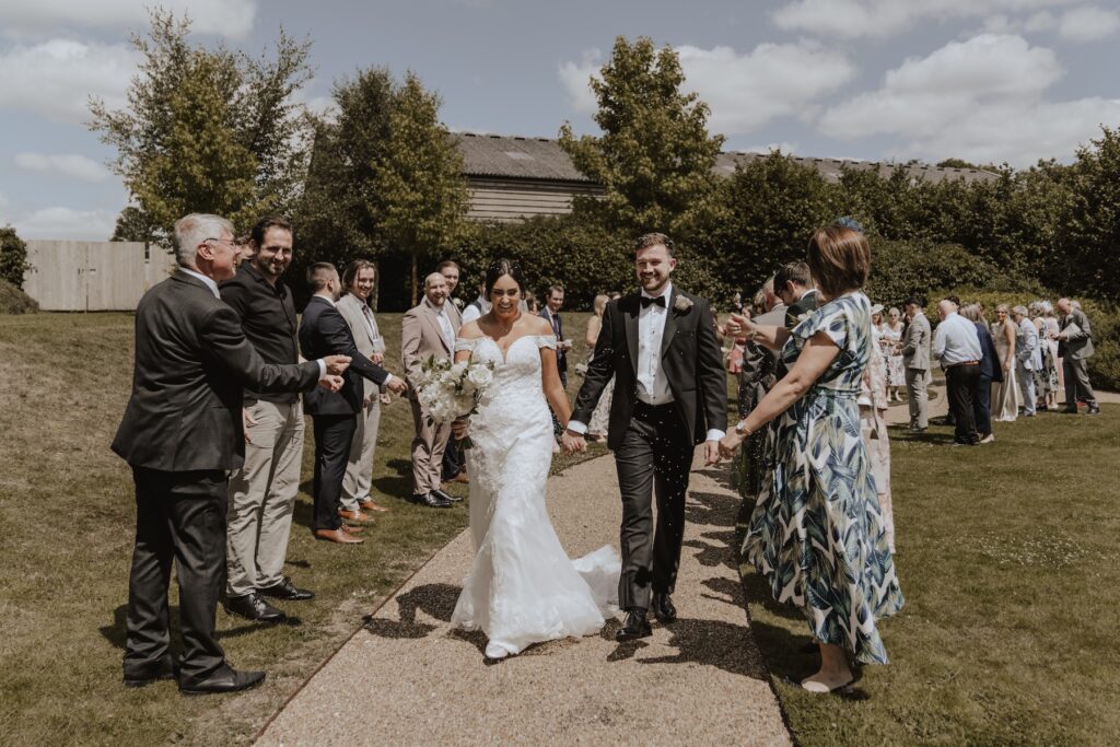 The post-ceremony confetti line with a couple at Easton Grange in Suffolk