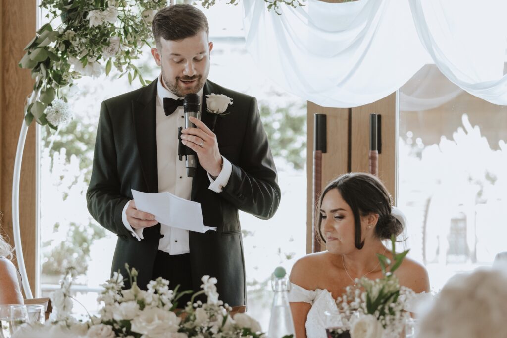 A newlywed couple during speeches on their wedding day at Easton Grange