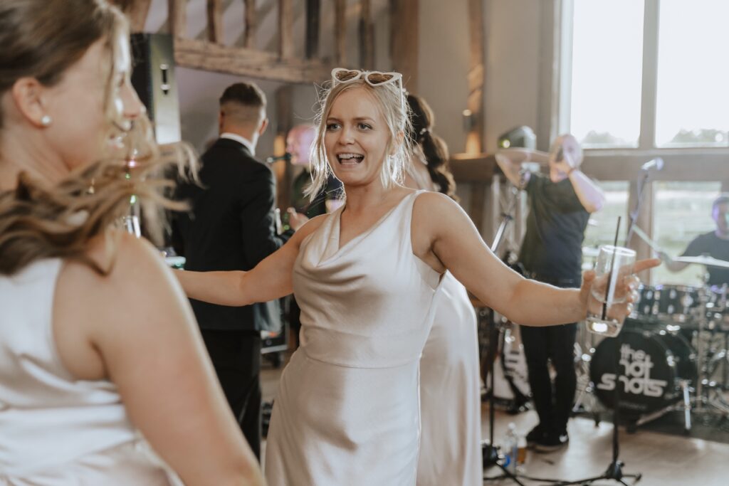 A bridesmaid dancing on the dance floor at Easton Grange during a Suffolk wedding
