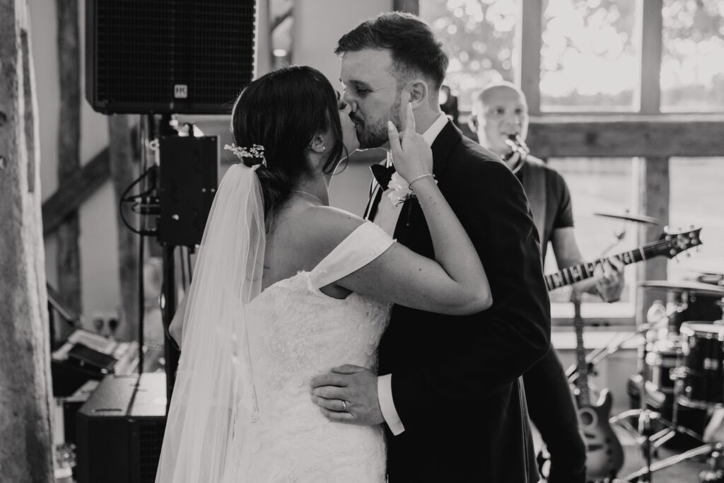 A bride and groom sharing a kiss whilst dancing on the dance floor at Easton Grange during a Suffolk wedding