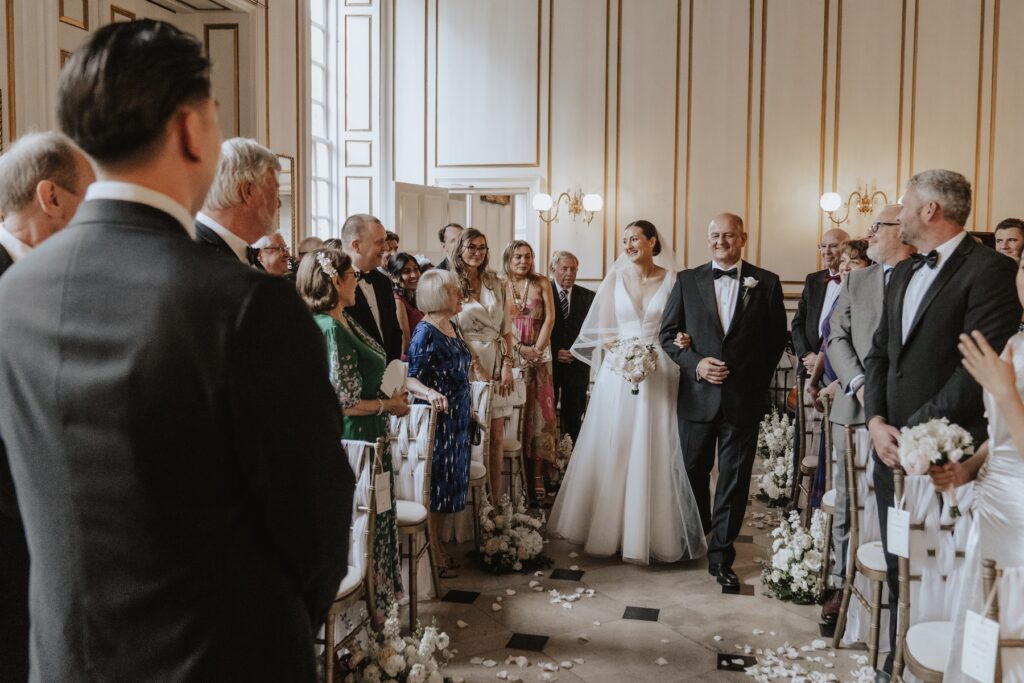 The bride walking down the aisle at Gosfield Hall