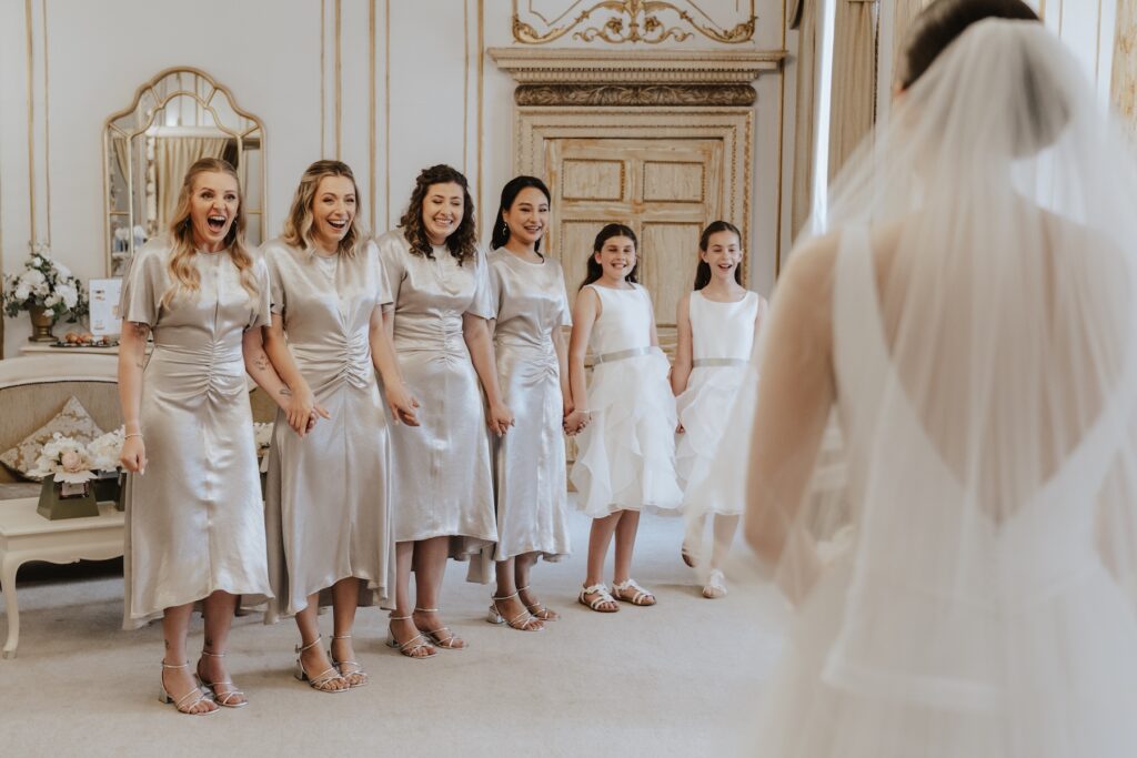 The bridesmaids looking at the bride for the first time at Gosfield Hall