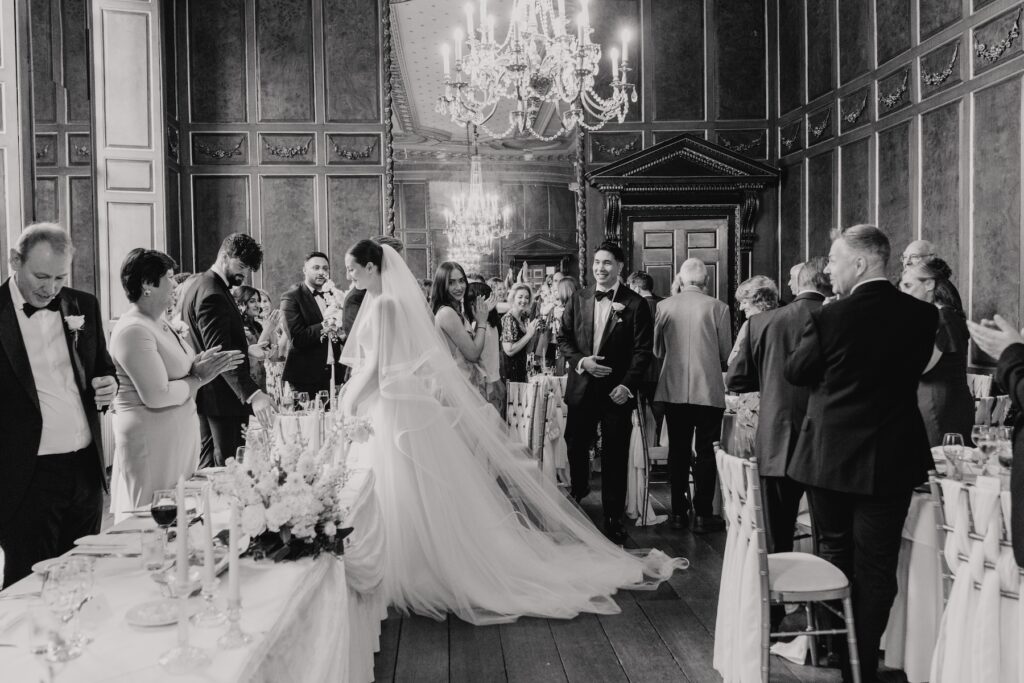 The couple entering their wedding breakfast at Gosfield Hall
