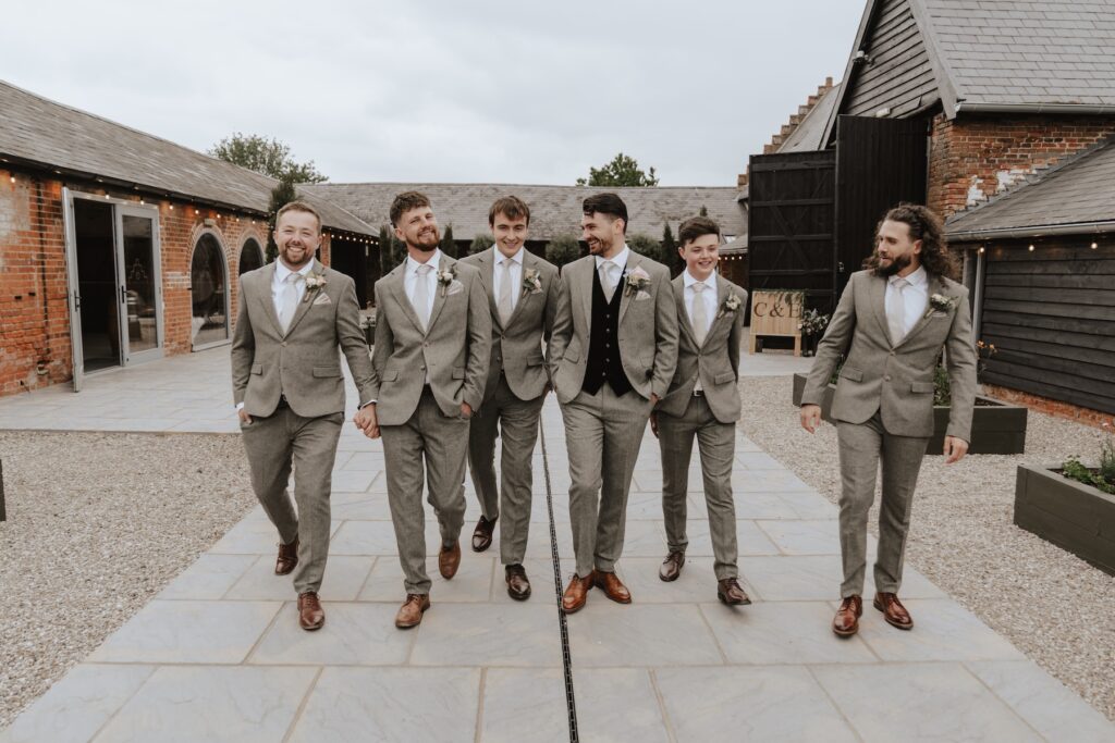 Groomsmen joking and getting ready together at Copdock Hall wedding morning