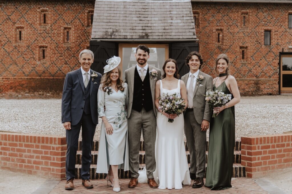 Family group photos on terrace at Copdock Hall wedding, Suffolk countryside backdrop