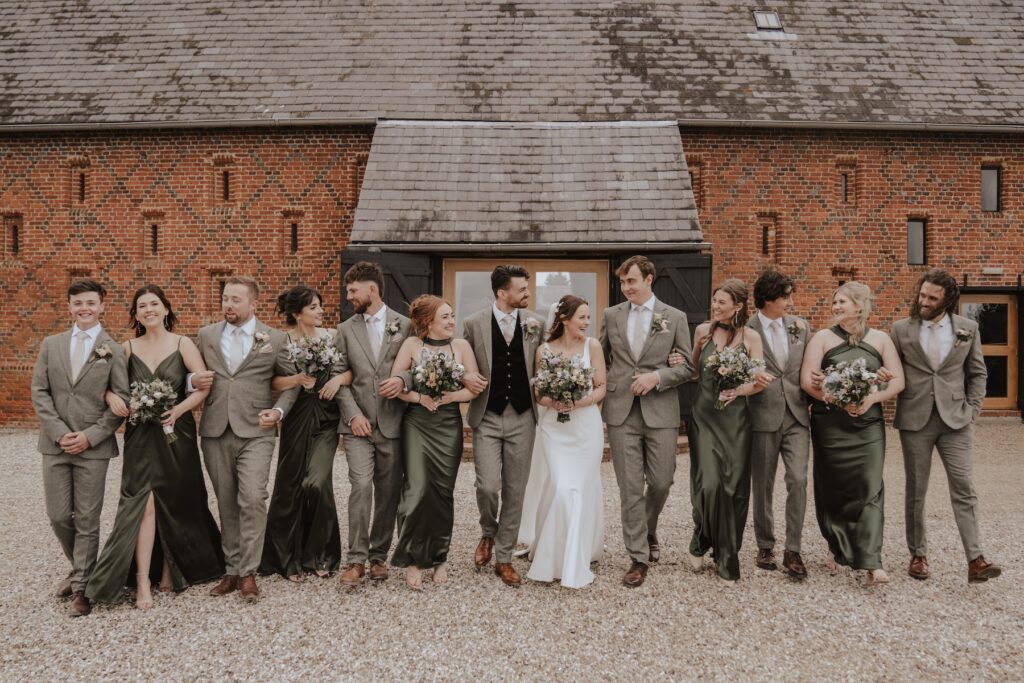 Couple laughing with friends during terrace photos at Copdock Hall
