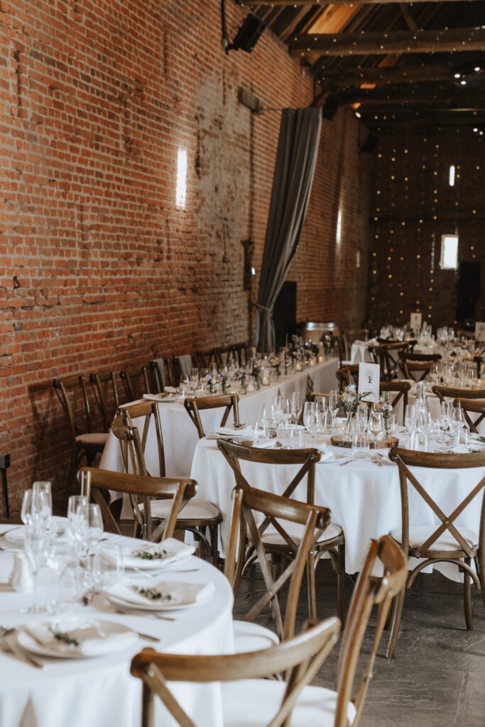 Wedding breakfast setup inside Copdock Hall with elegant bud vases and simple décor
