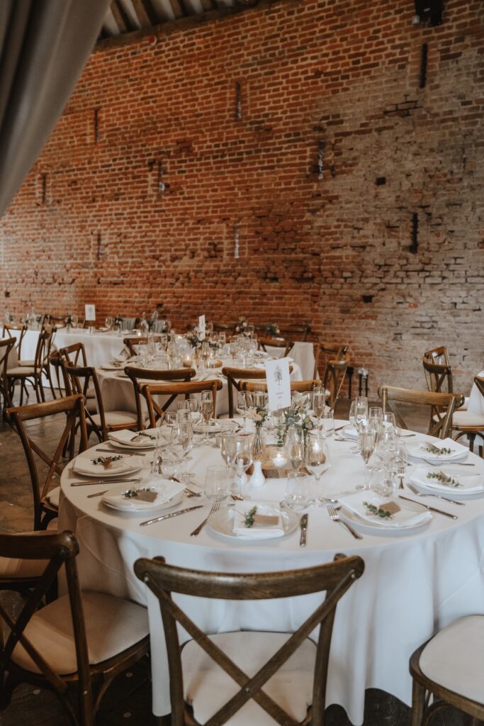 Wide shot of rustic Copdock Hall interior ready for dinner reception