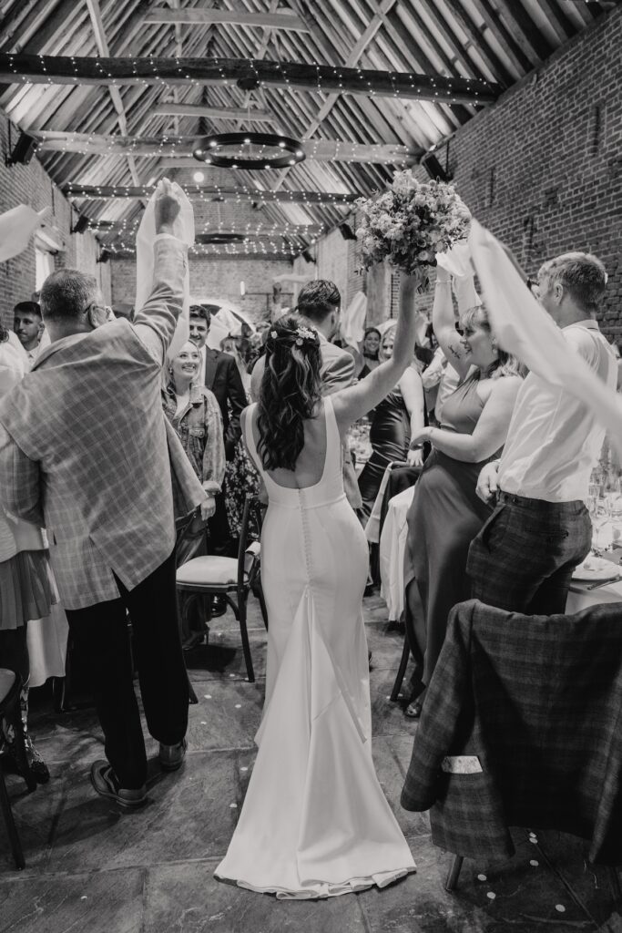 Bride and groom walking into wedding breakfast room