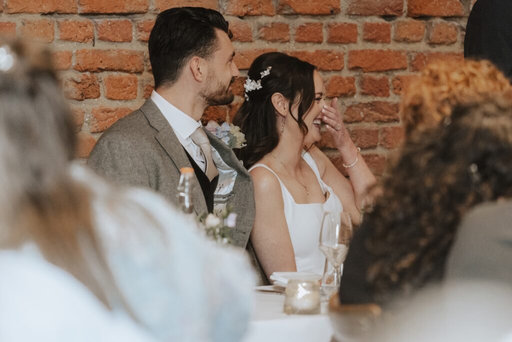 Bride and groom listening to speeches during Copdock Hall wedding dinner