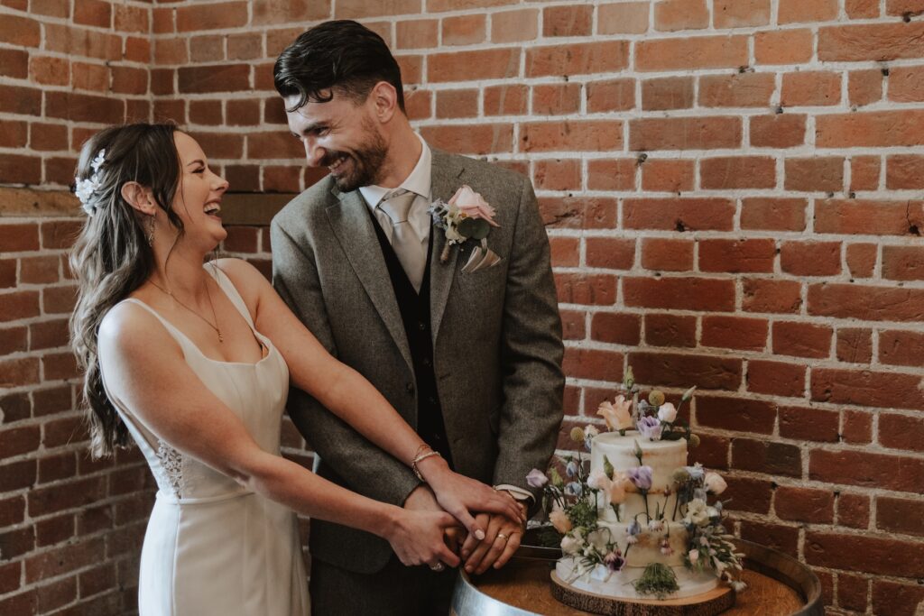 Bride and groom cutting cake together at Copdock Hall wedding reception