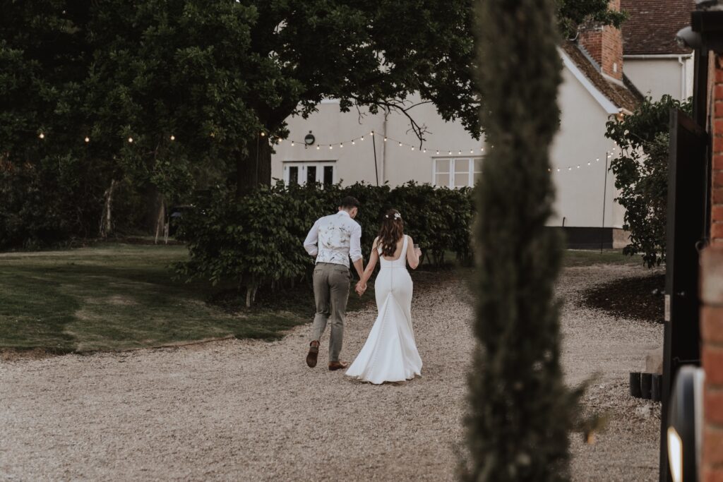 Couple walking together outside Copdock Hall, Suffolk wedding photographer