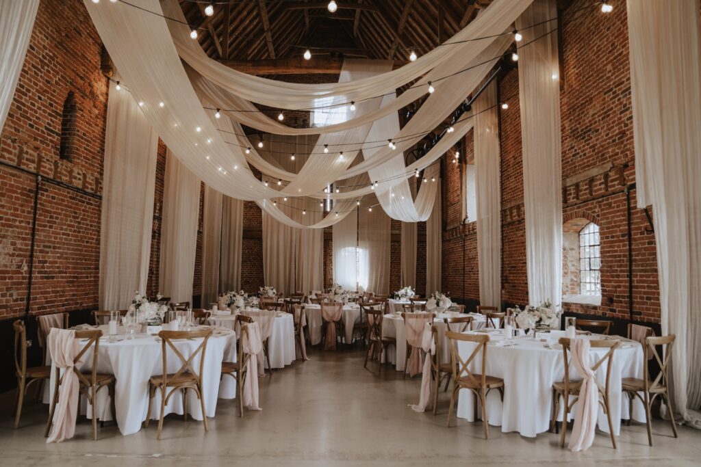 Pastel pink wedding breakfast setup with floral centrepieces at Godwick Hall