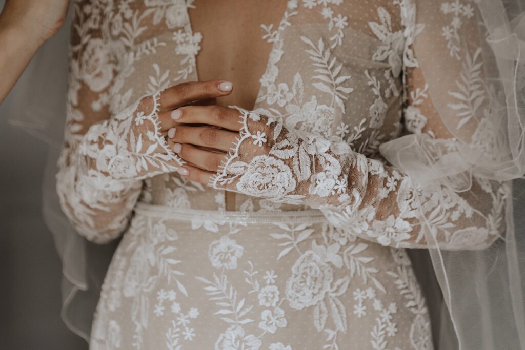 Close up of the bride's hands whilst getting into dress at Godwick Hall
