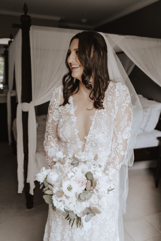 Bride in lace gown surrounded by bridesmaids, photographed in Norfolk