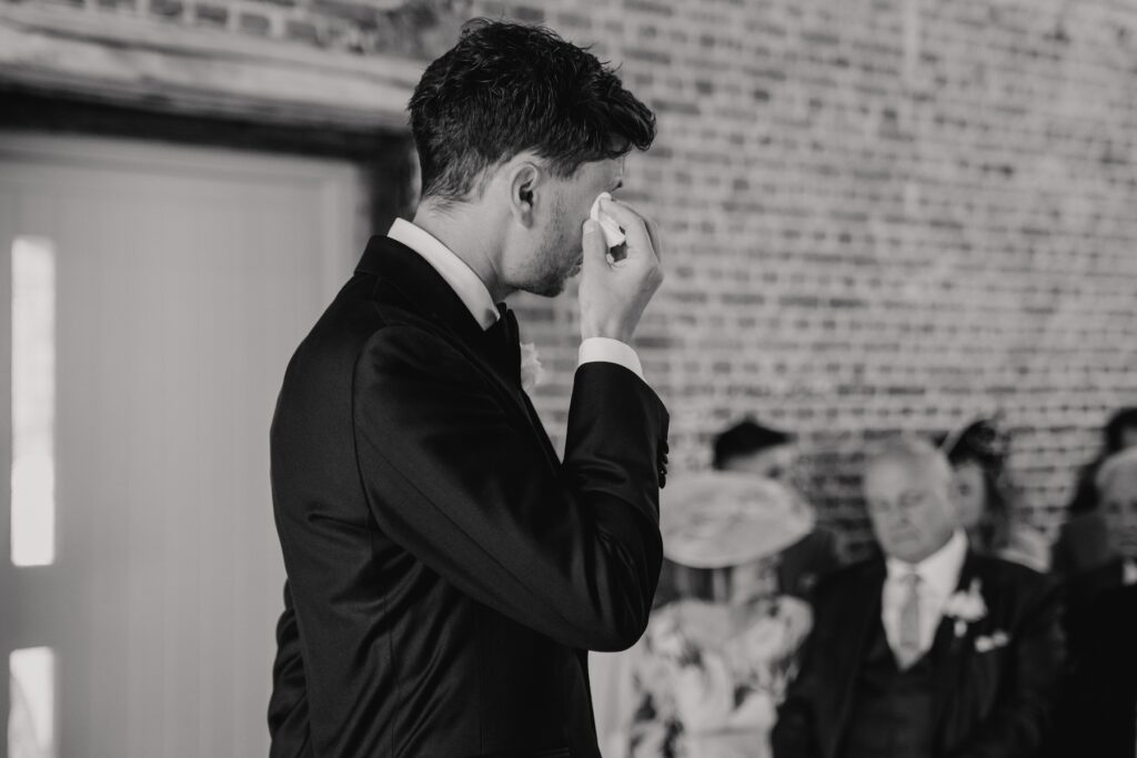 Norfolk wedding photographer capturing the groom crying at the bride's reaction
