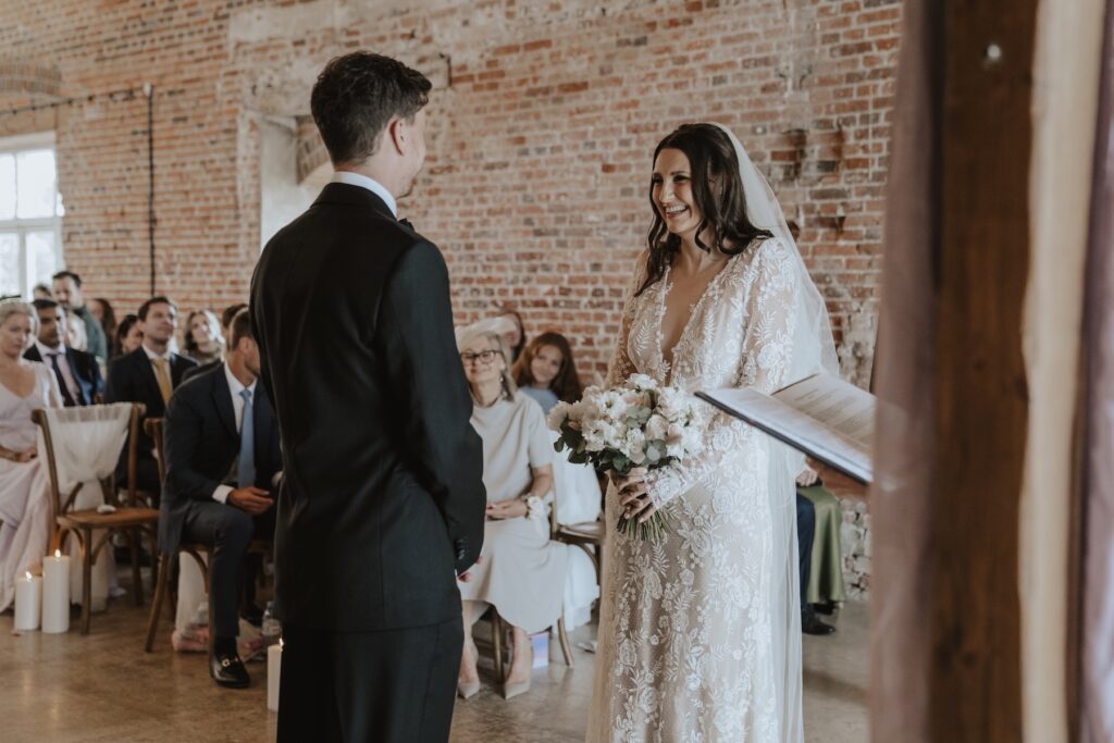 Emotional ceremony with brick backdrop at Godwick Hall Norfolk