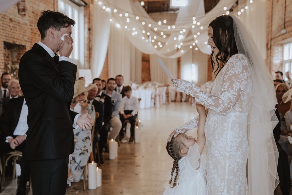 Couple exchanging handwritten vows inside Great Barn, Norfolk wedding